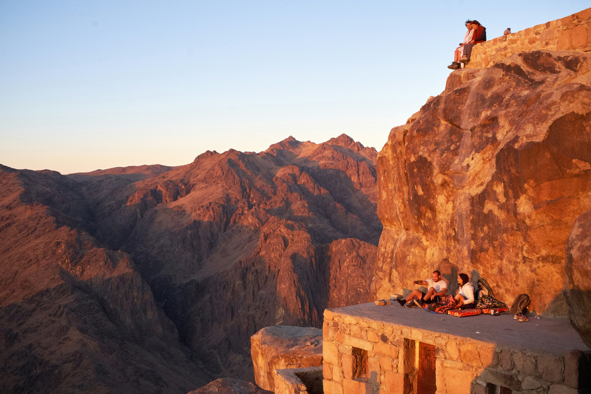 A view overlooking the mountains in Mount Sinai, Egypt as the hills take on rosy and golden hues.